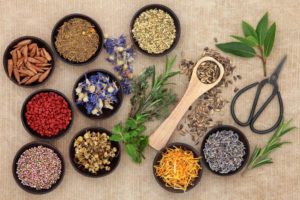 A table topped with bowls of different types of herbs.