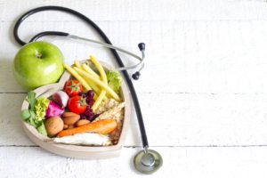 A stethoscope and some food on top of a table.